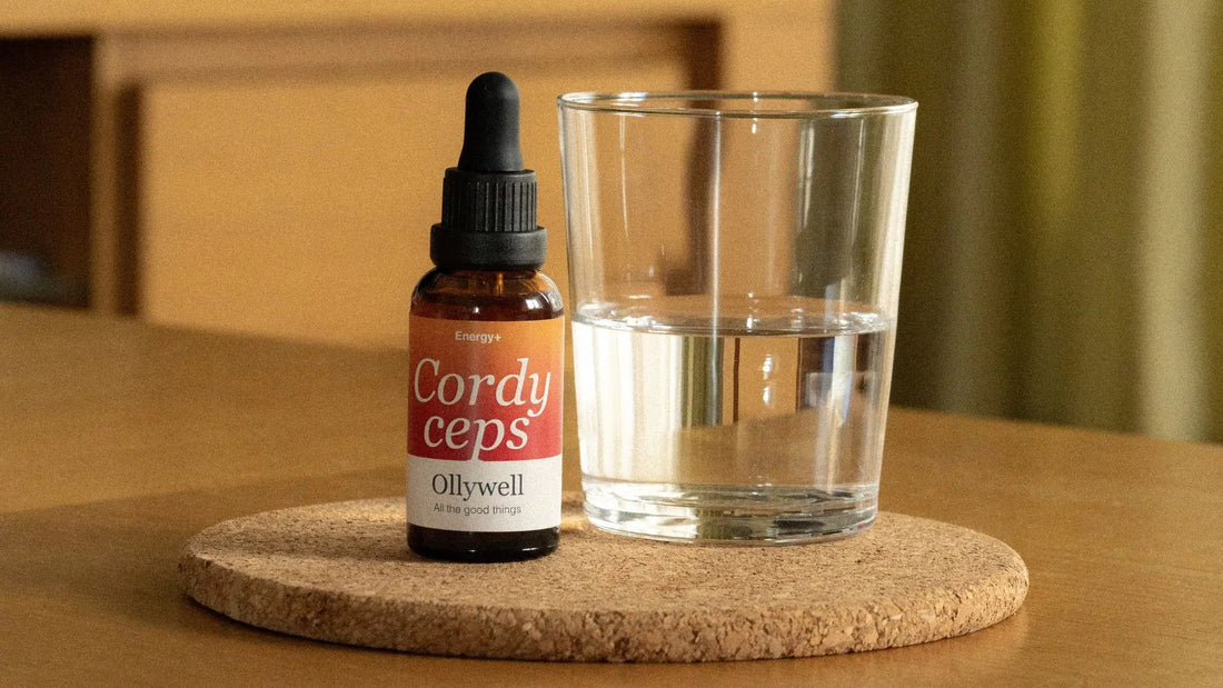 On the table is a glass of water and liquid Cordycep extract from Ollywell.