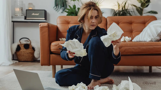 A stressed woman looking through crumpled papers.